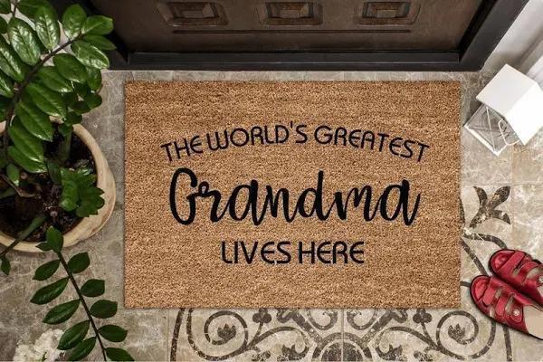 The World’S Greatest Grandma Lives Here Printed Floor Rug Housewarming Gift Home Living Home Decor Indoor Outdoor Doormat Floor Mat Funny Gift Ideas Warm House Gift Welcome Mat