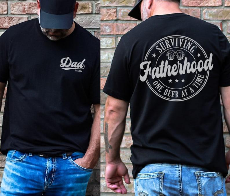 Surviving Fatherhood One Beer At A Time 2 Sided Shirt, Father’s Day Shirt, Best Dad Ever, Funny Dad Shirt, Trendy Fathers Day, Men’s Graphic Tees